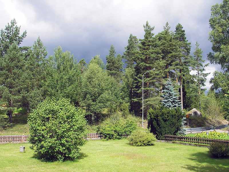 Garten vor der Villa in Richtung praktischer Straßenanbindung Galeriebild Klövdala - pflegeleichtes Wohnhaus in heller Dorfrandlage und Flussnähe im Herzen von Småland